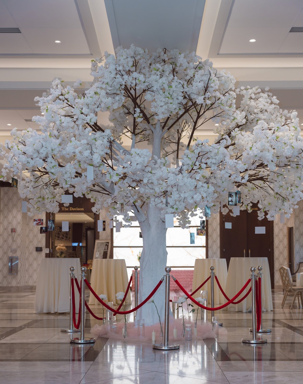White blossom tree welcoming guests in a marble ballroom