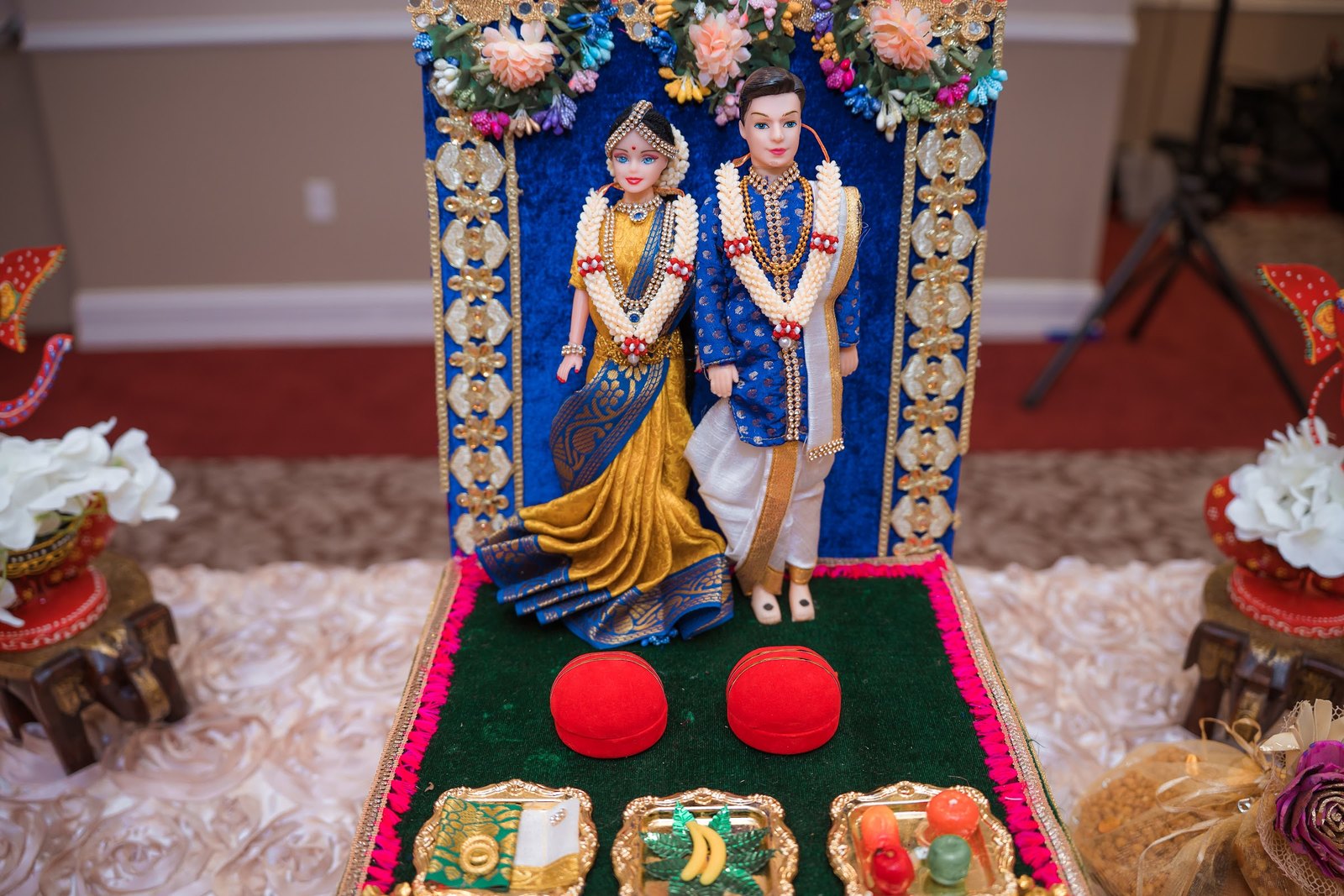 Decorated bride and groom doll display with fruit and flowers