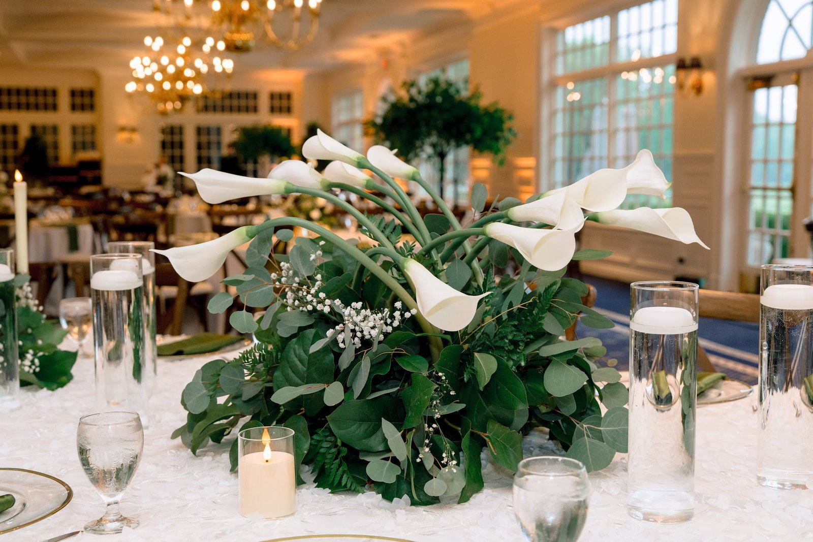 Calla lilies and greenery with floating candles
