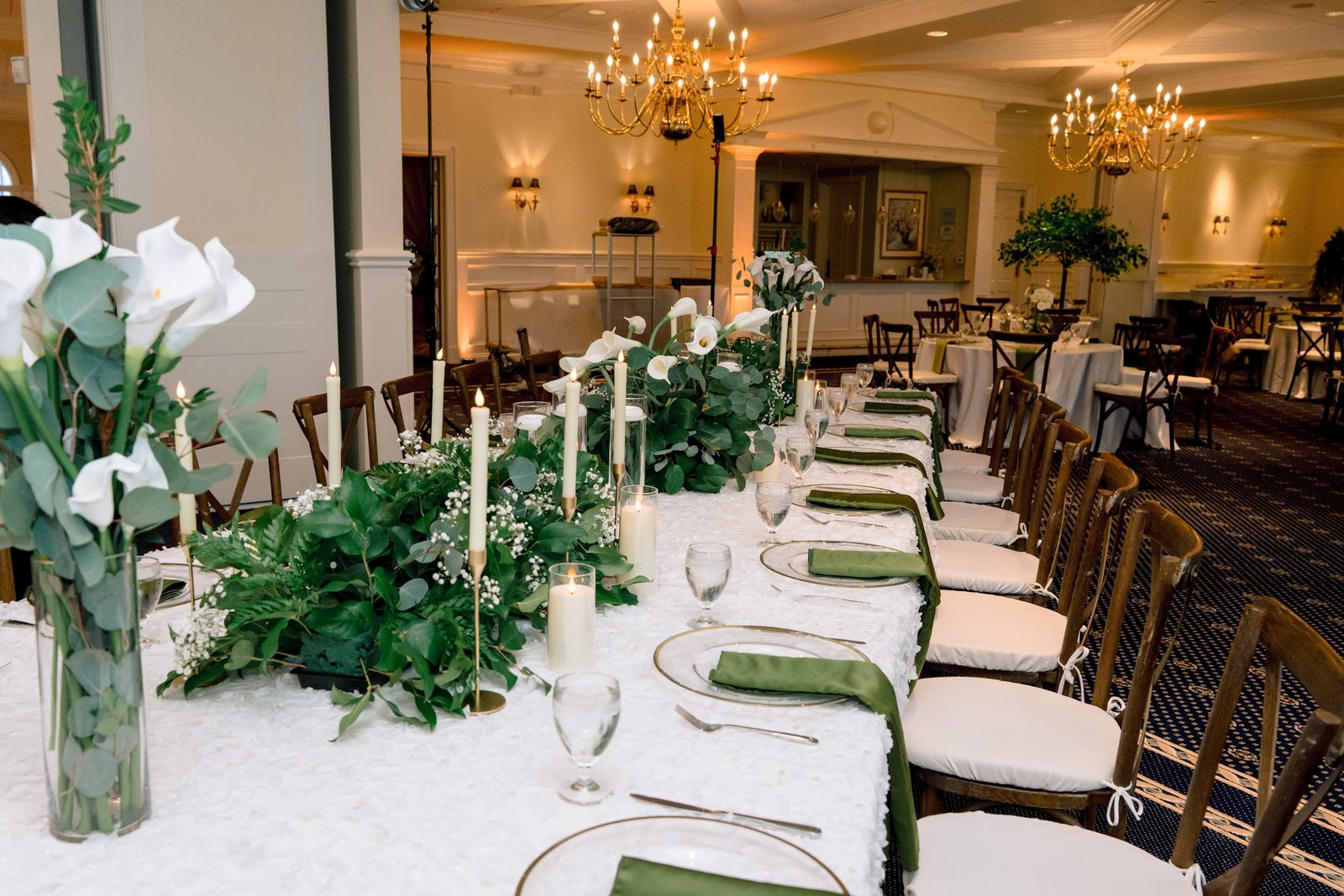 Long reception table with greenery, calla lilies and taper candles