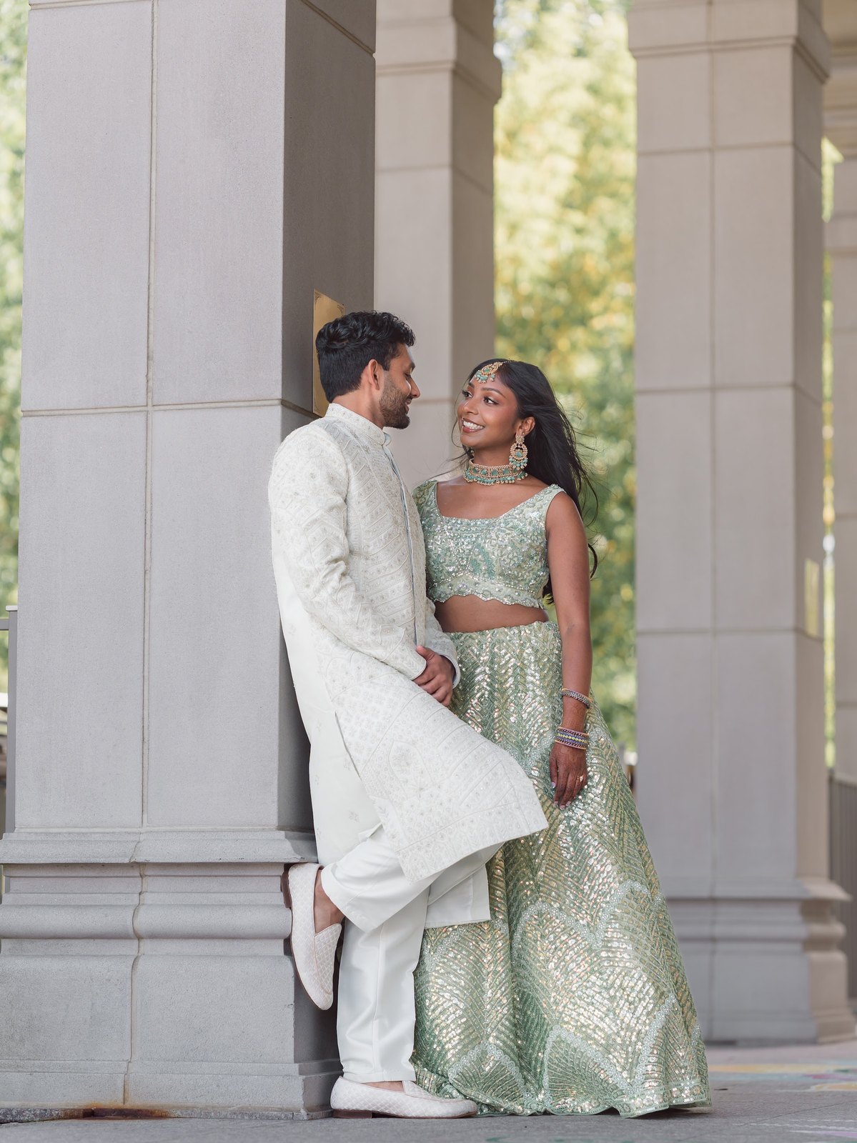 Couple posing between tall white pillars