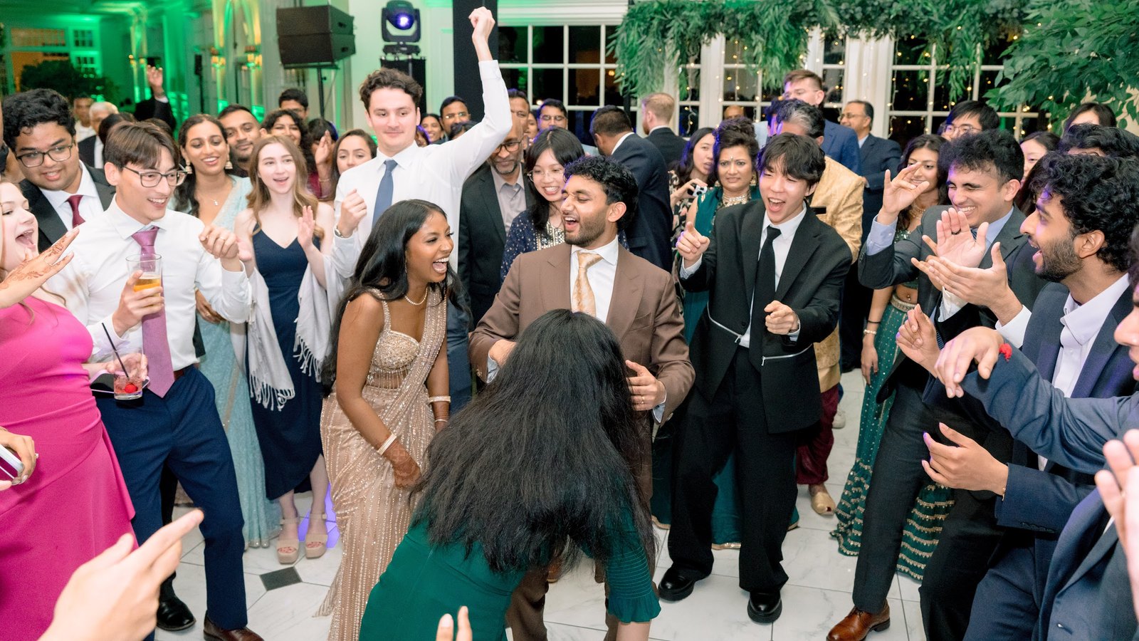 Guests dancing together under green lights