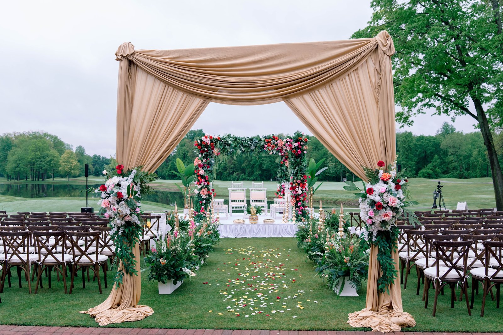 Champagne draped entrance leading to a floral garden mandap