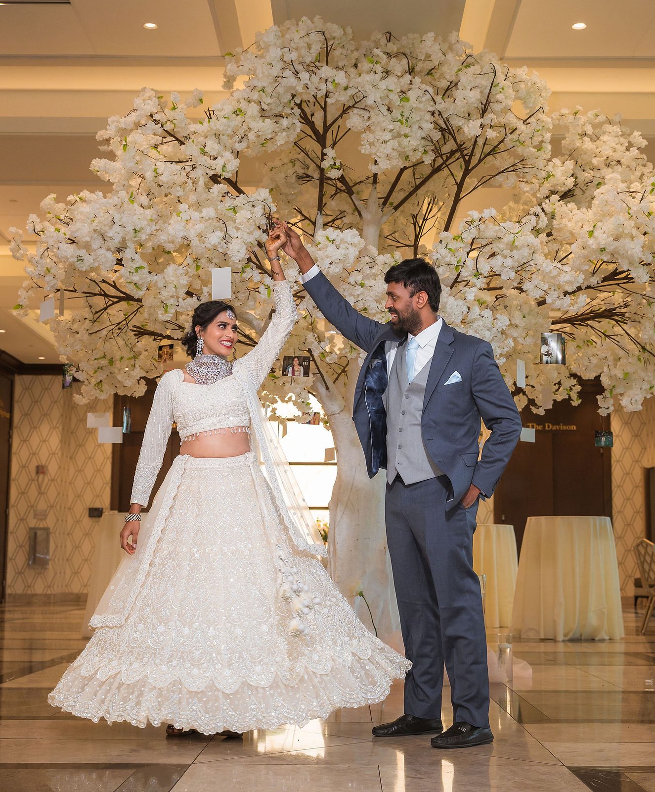 Couple twirling beneath a white blossom tree