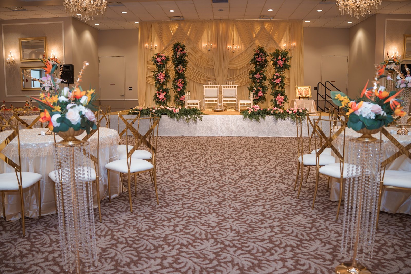 Ballroom with a floral stage and crystal centerpieces