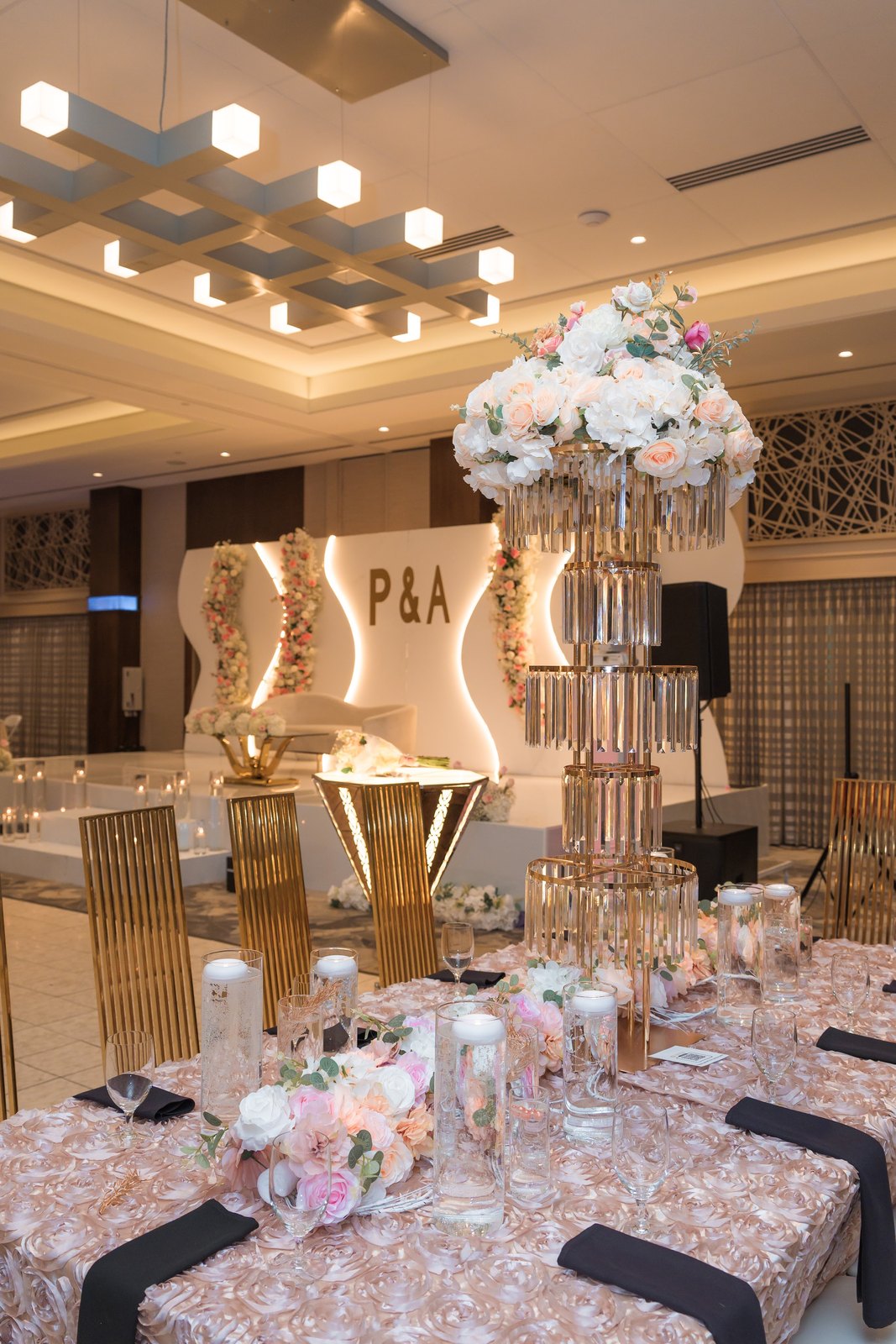 Tall crystal stands topped with blush roses over reception tables
