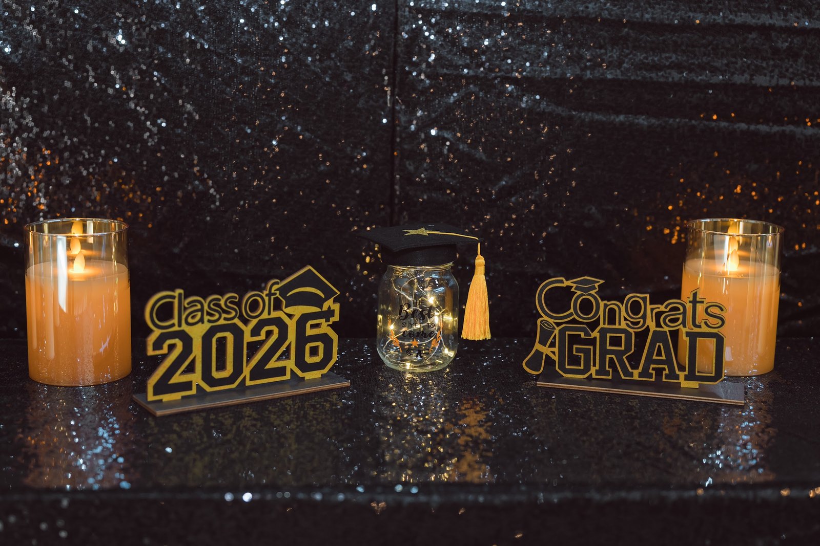 Class of 2026 and Congrats Grad signs between candles