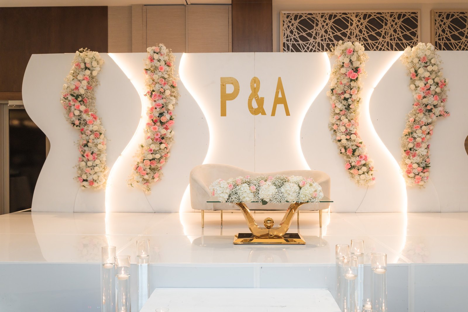 White illuminated monogram stage with floral columns