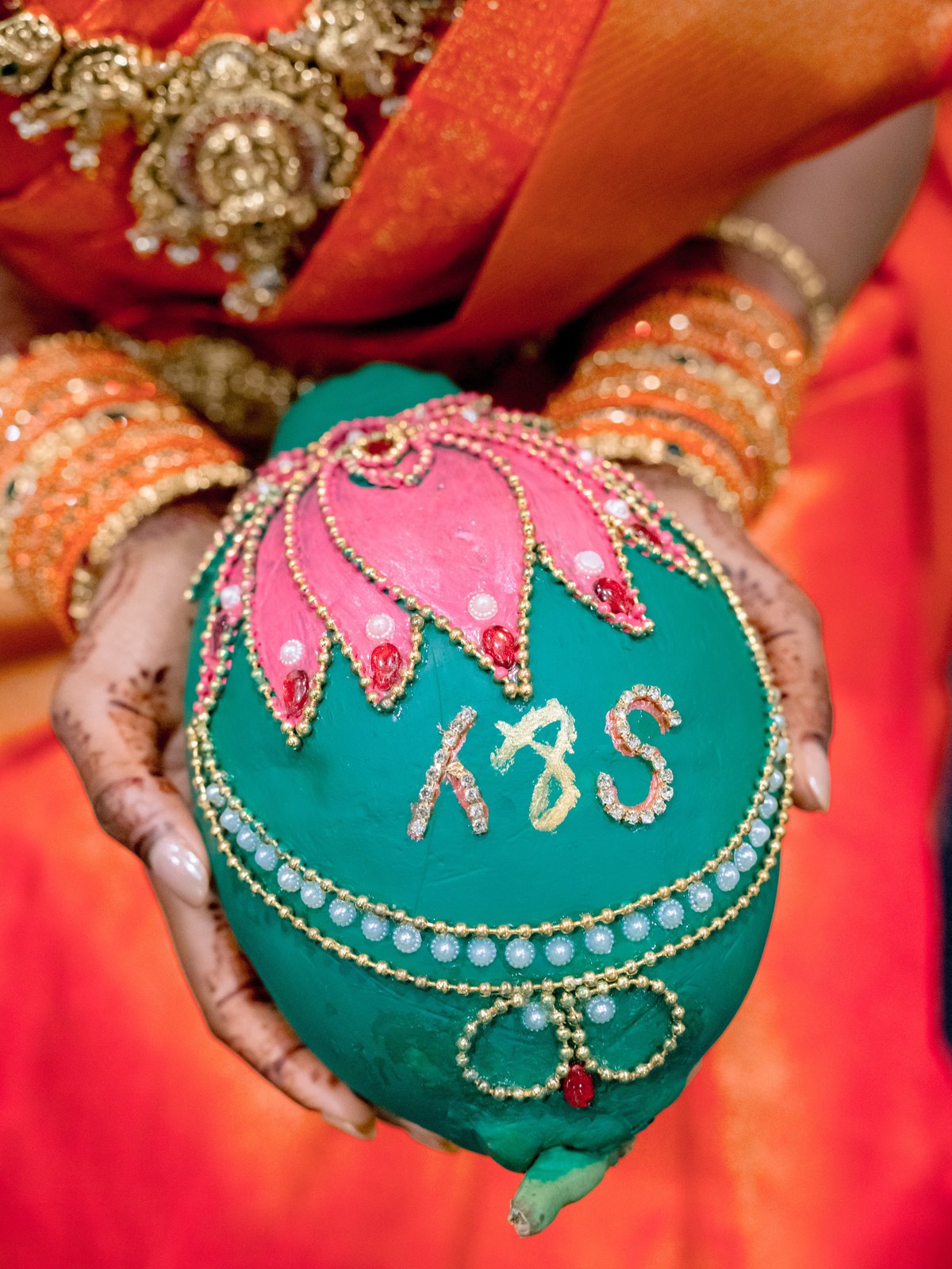 Bride holding a painted and beaded coconut