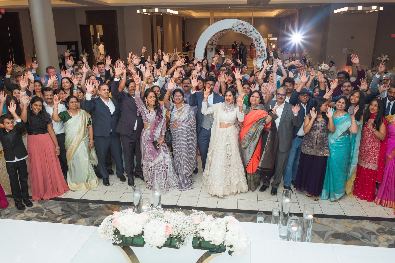 Reception guests cheering and waving in front of the stage